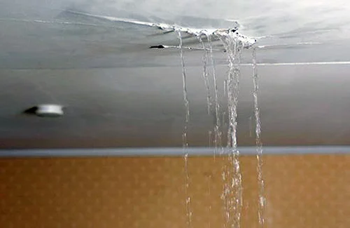 Water leaking through a ceiling from roof damage