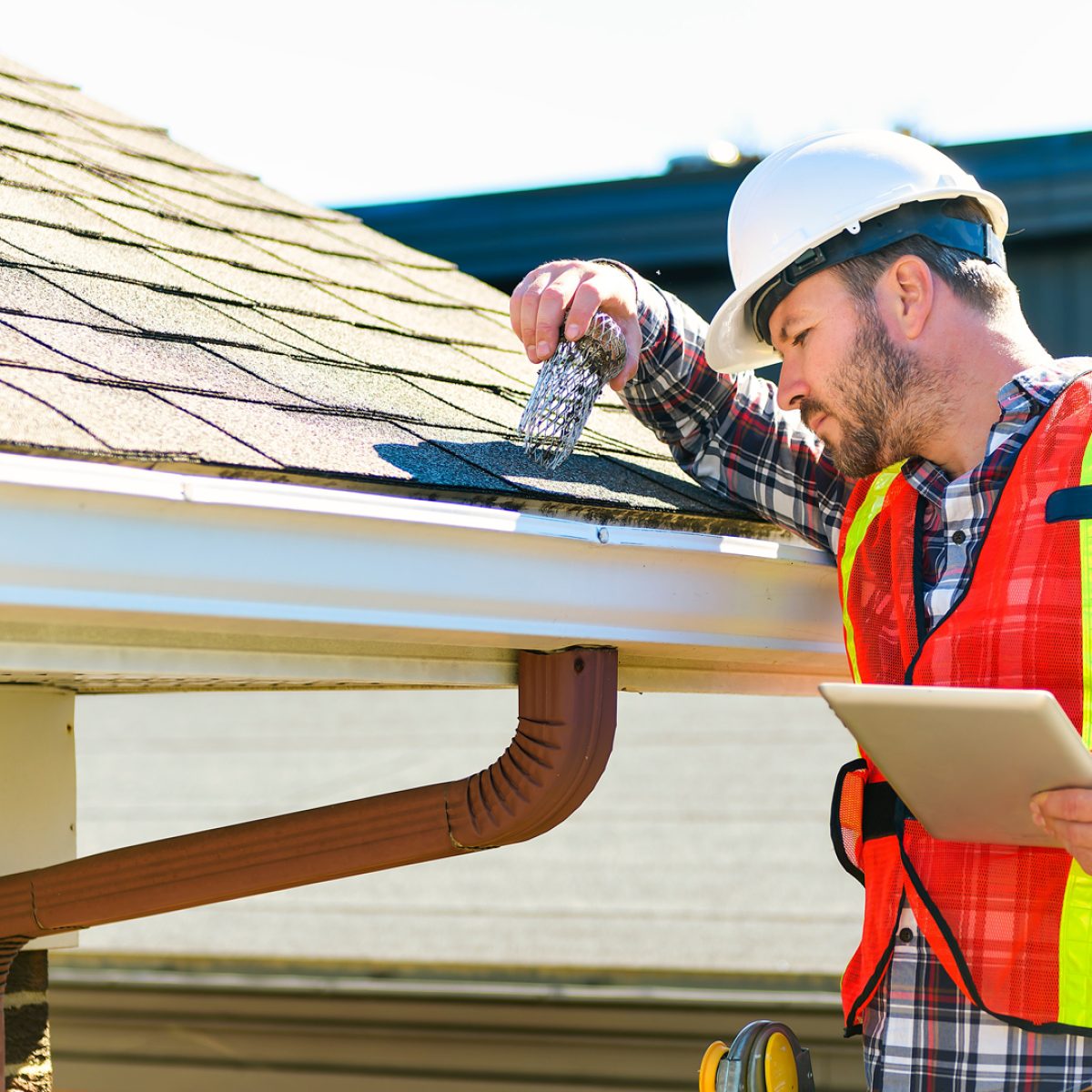 Roof repair contractor inspecting a residential roof